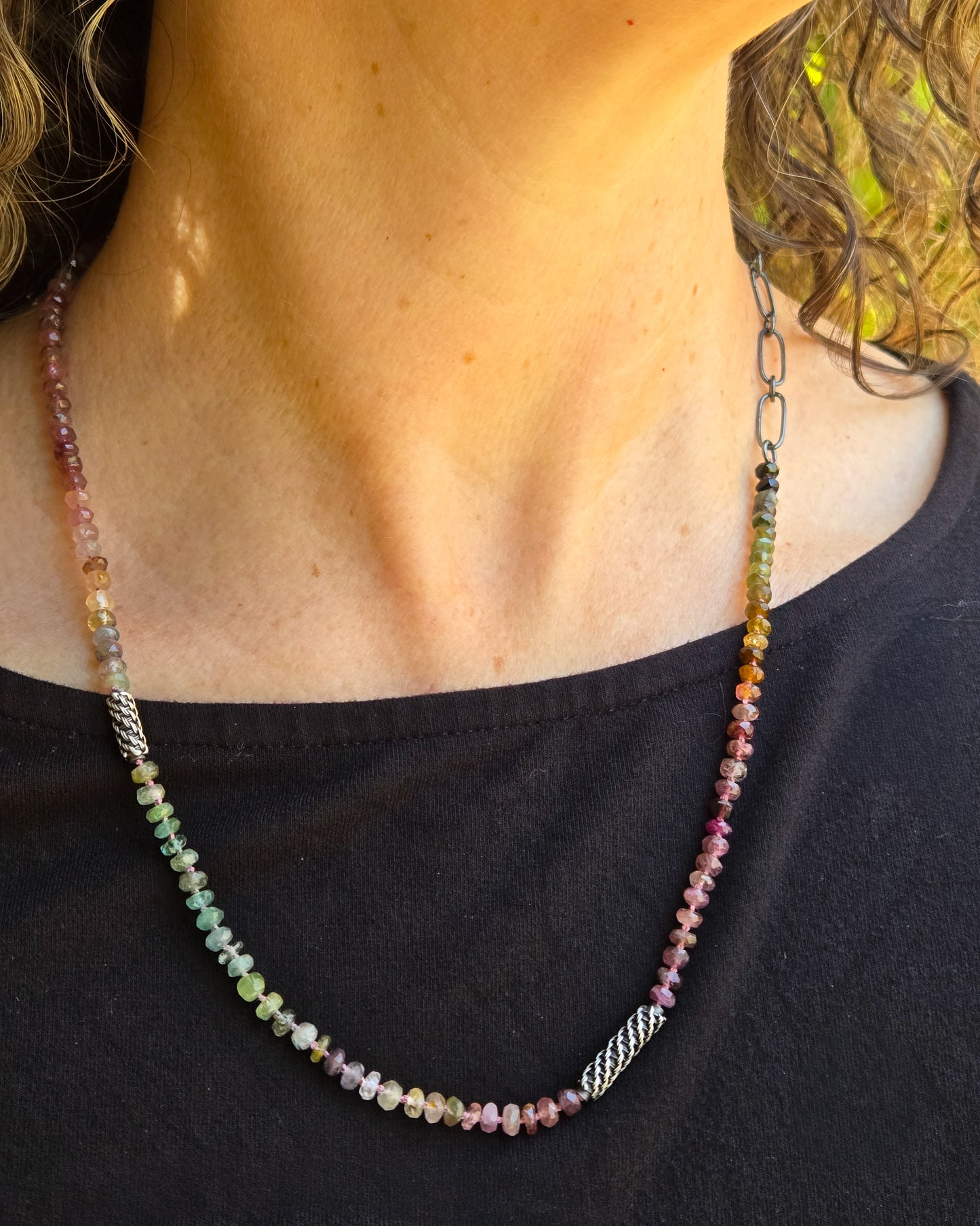 Multicolored beaded necklace on a person wearing a black top