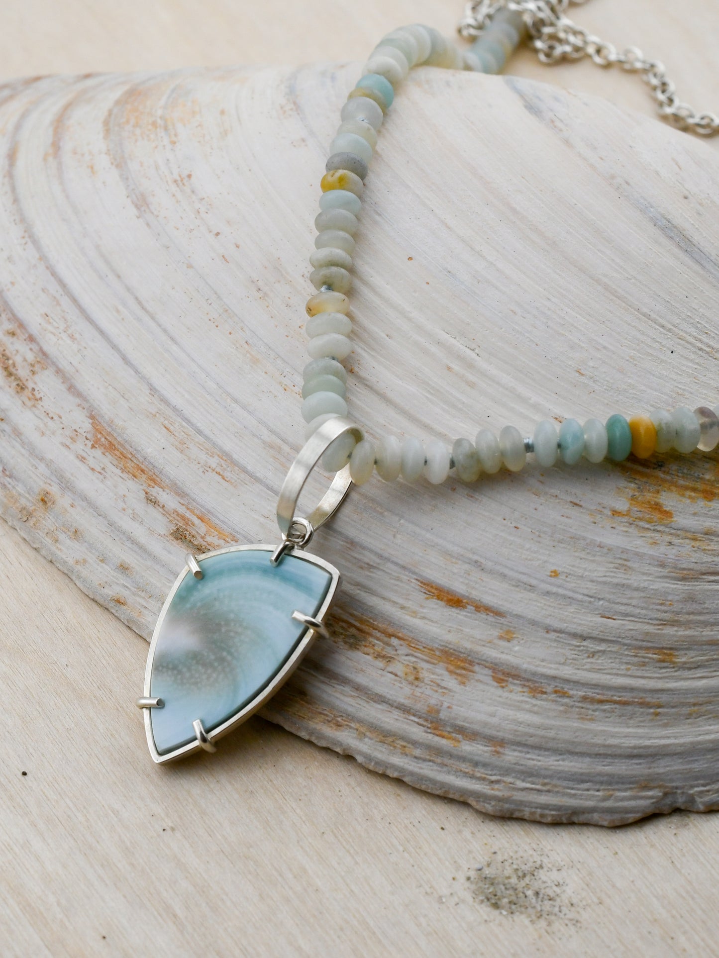 Amazonite beaded necklace with Shiva shell pendant on a neutral background