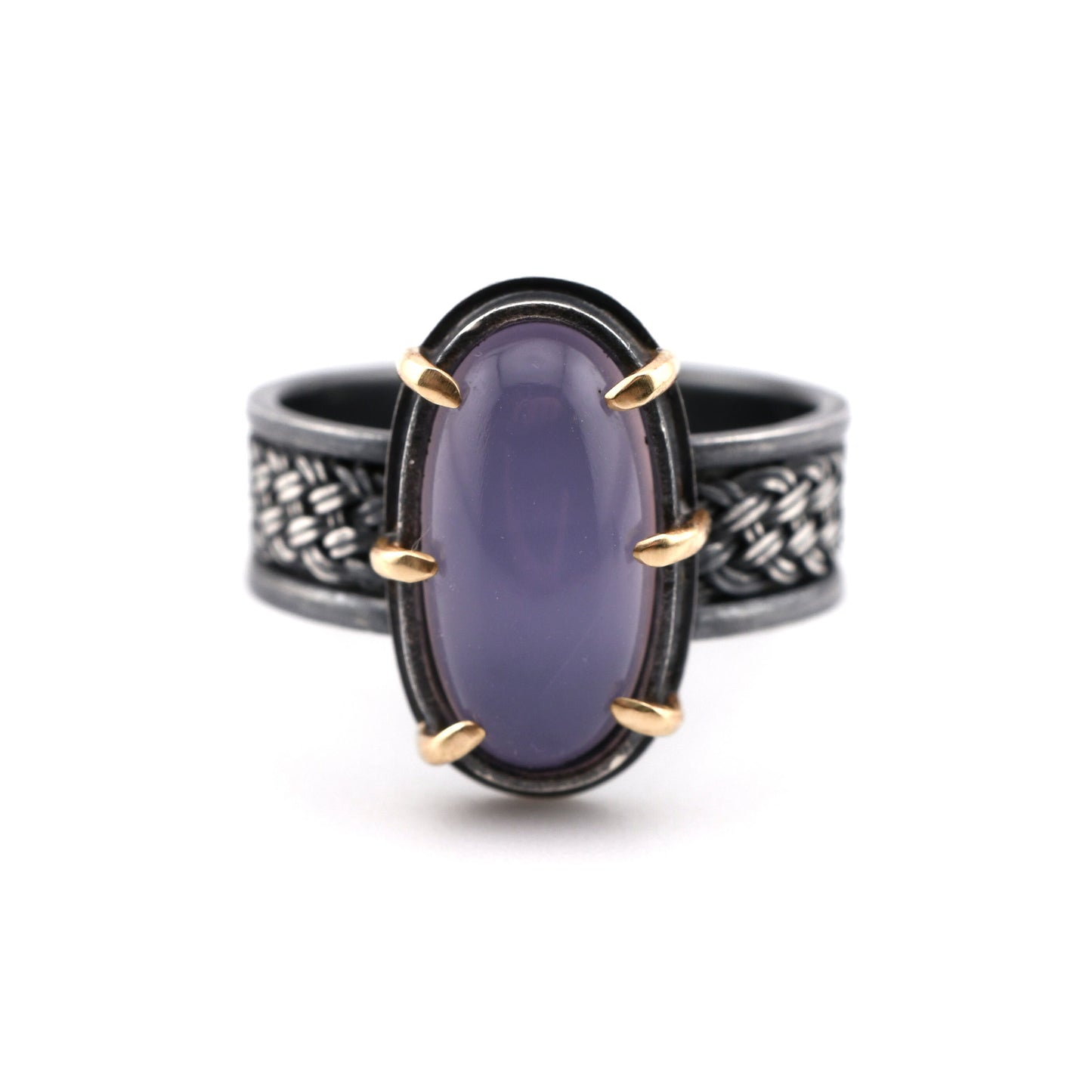 Ring with purple stone and gold accents on a white background