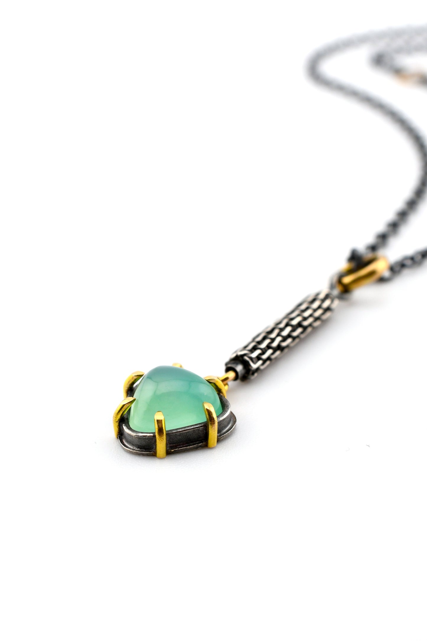Necklace with a green gemstone pendant on a white background