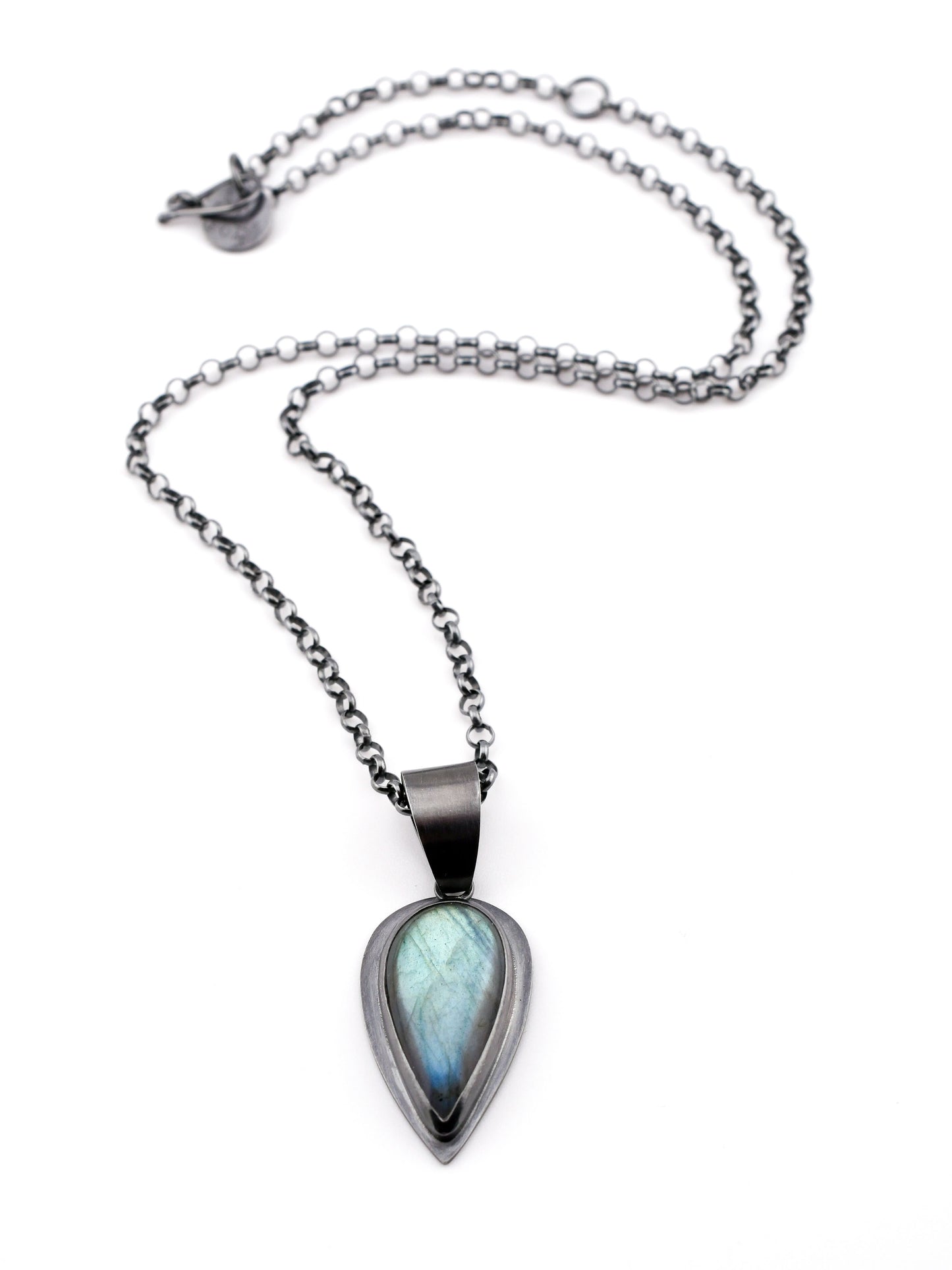 Talon shaped Labradorite pendant in blackened silver with black silver chain on a white background