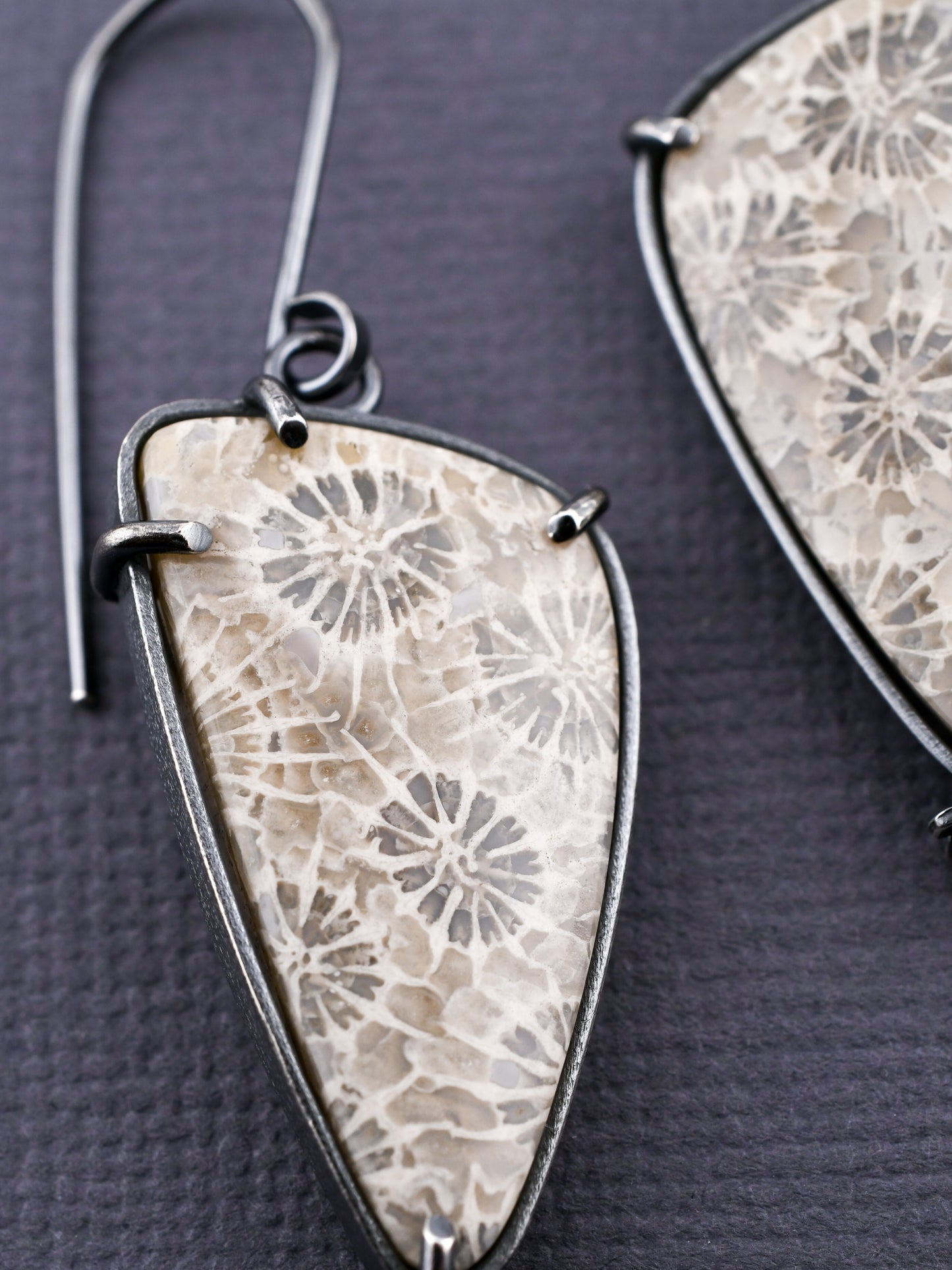closeup of floral stone earring on a dark textured background