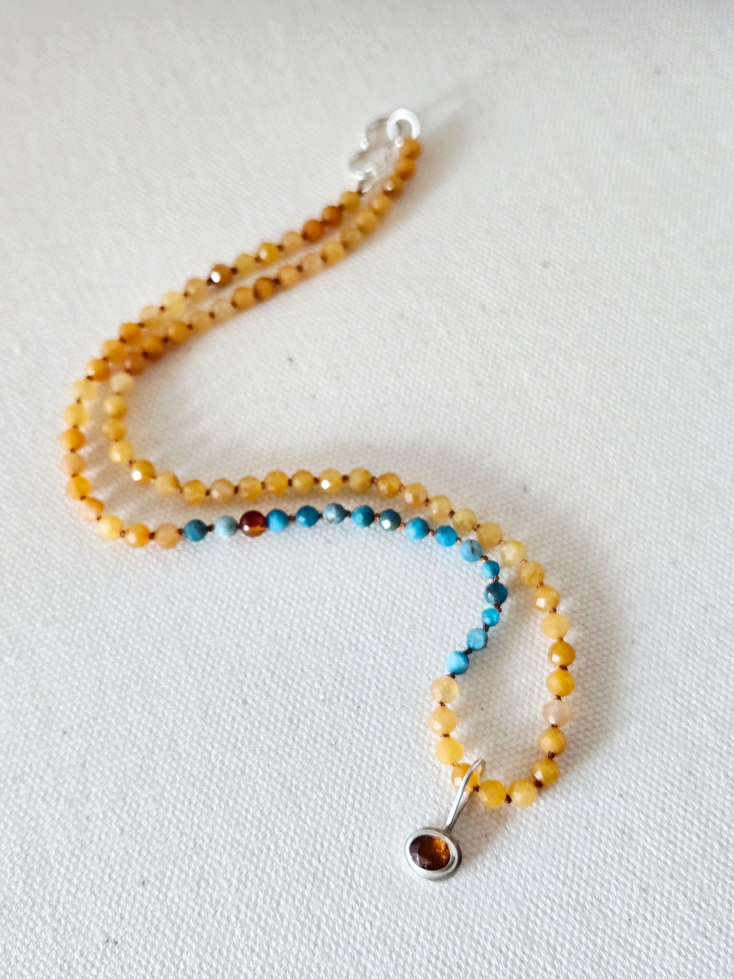 Beaded necklace with a silver clasp on a light background