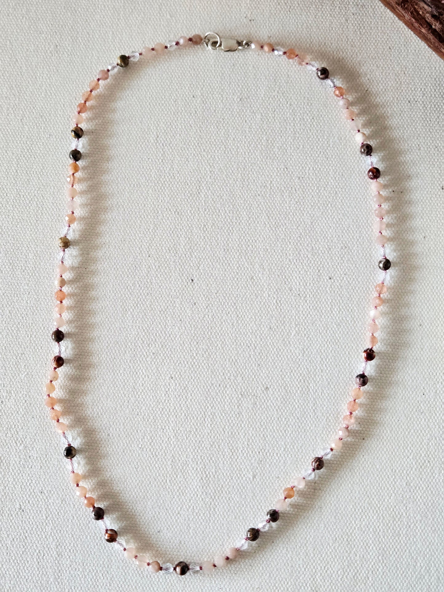 Beaded necklace on a textured beige surface