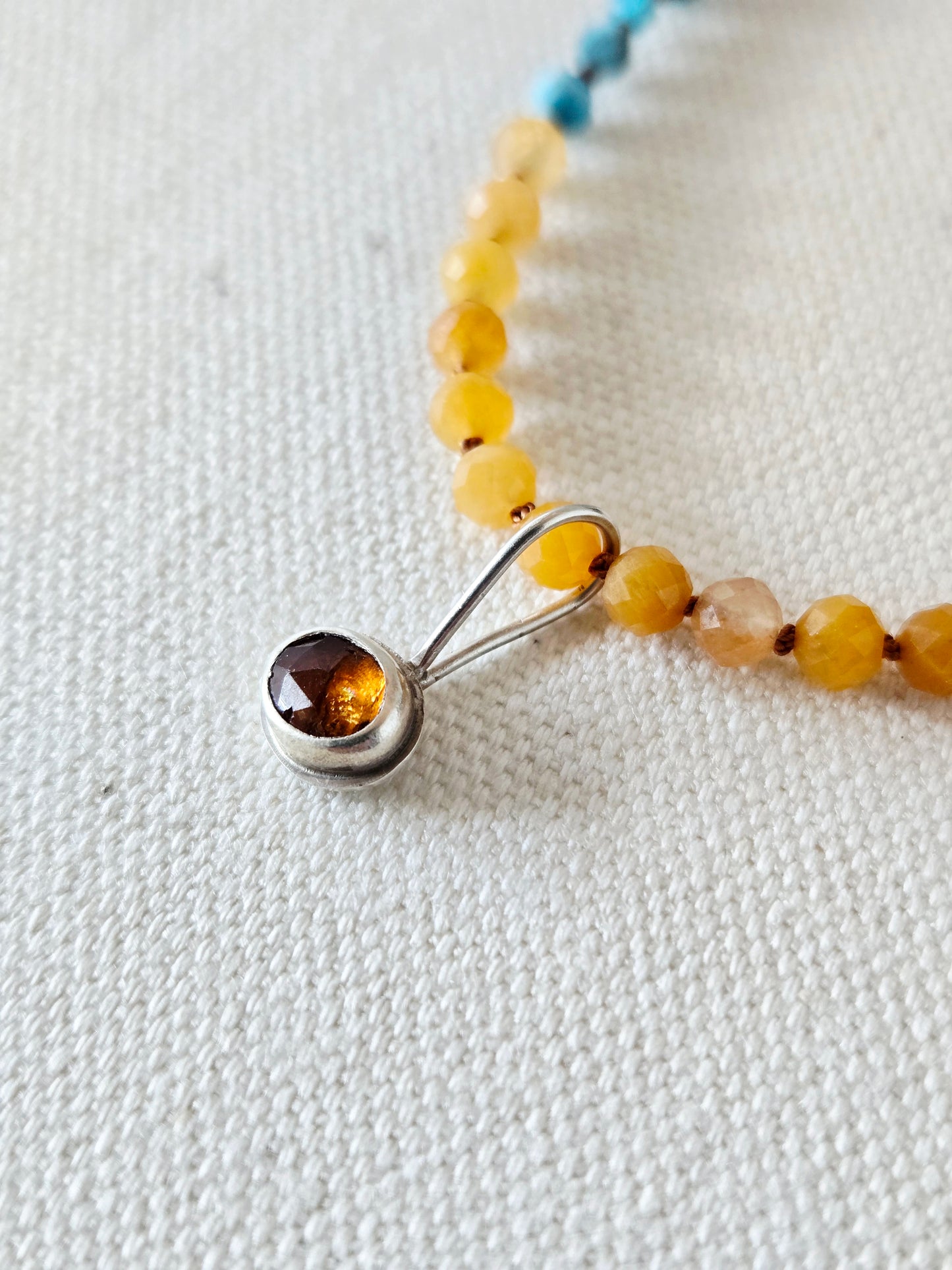 Close-up of a beaded necklace with a silver clasp on a light background