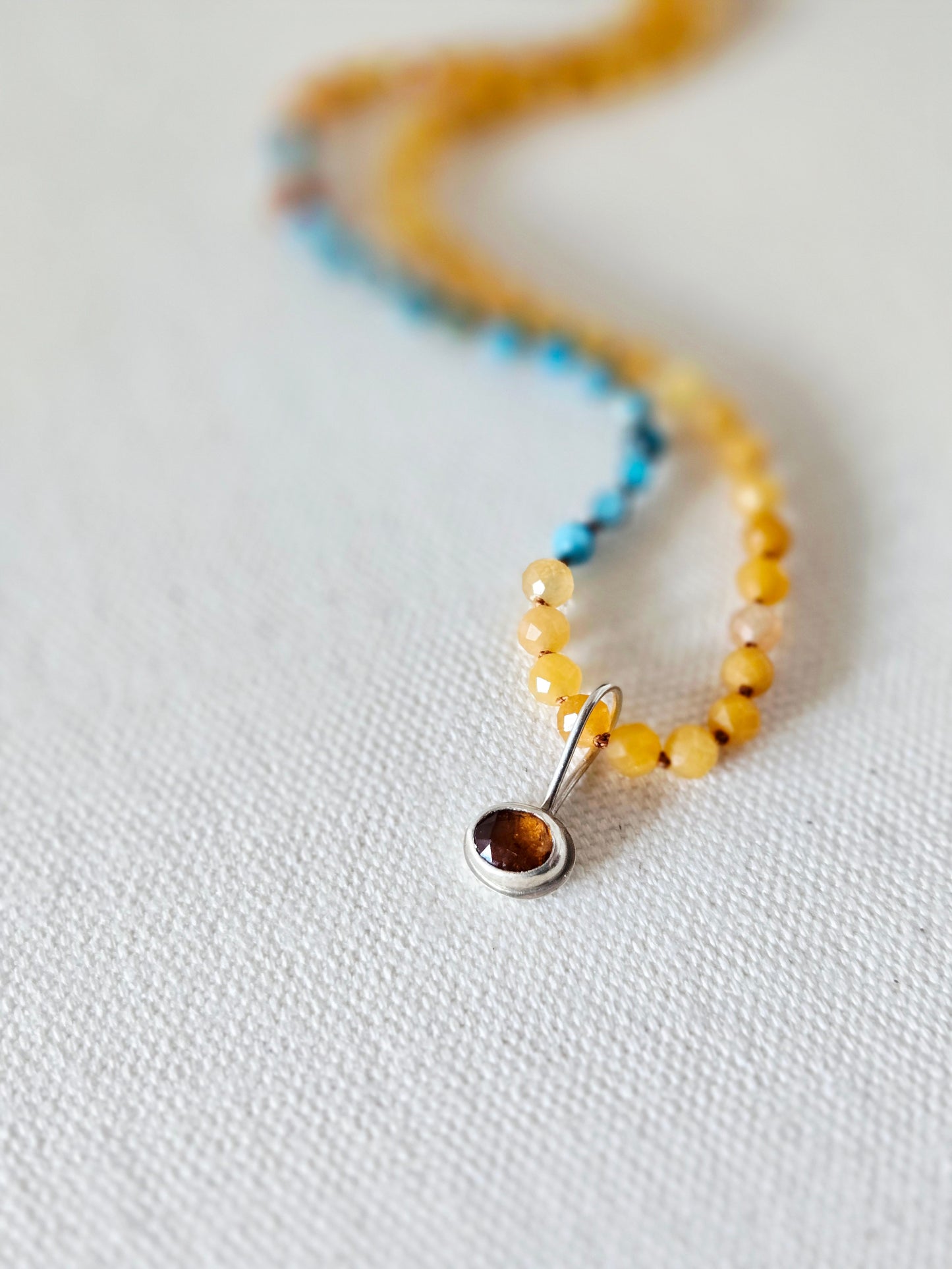Necklace with a pendant on a light fabric background
