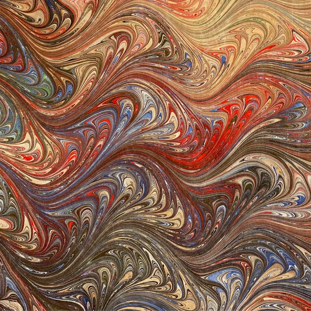 closeup of hand-dyed marbled silk cloth in shades of sienna red blue and black