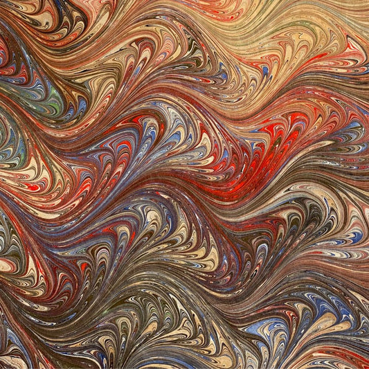 closeup of hand-dyed marbled silk cloth in shades of sienna red blue and black