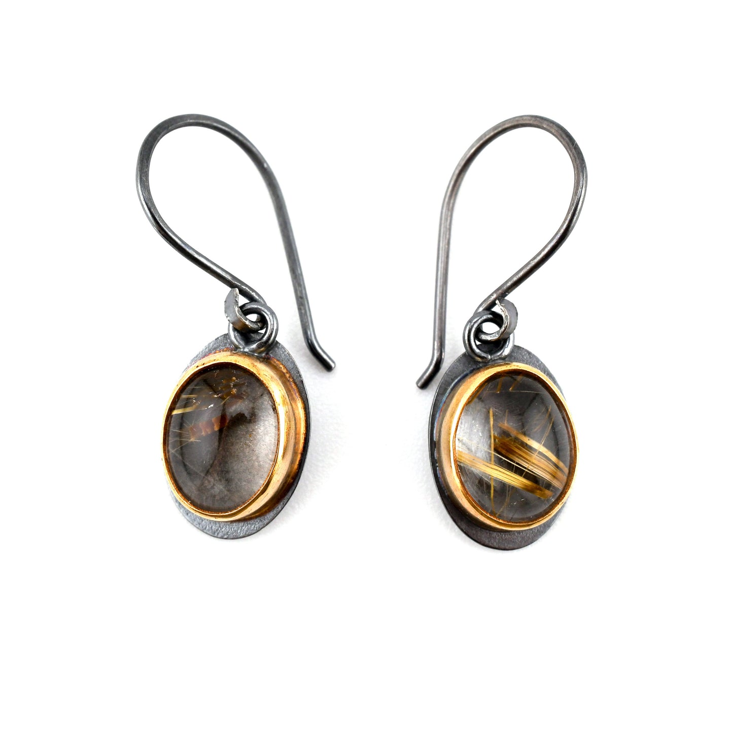 Pair of earrings with oval gemstones and gold accents on a white background