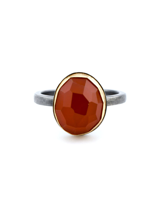 Ring with a red faceted stone on a white background