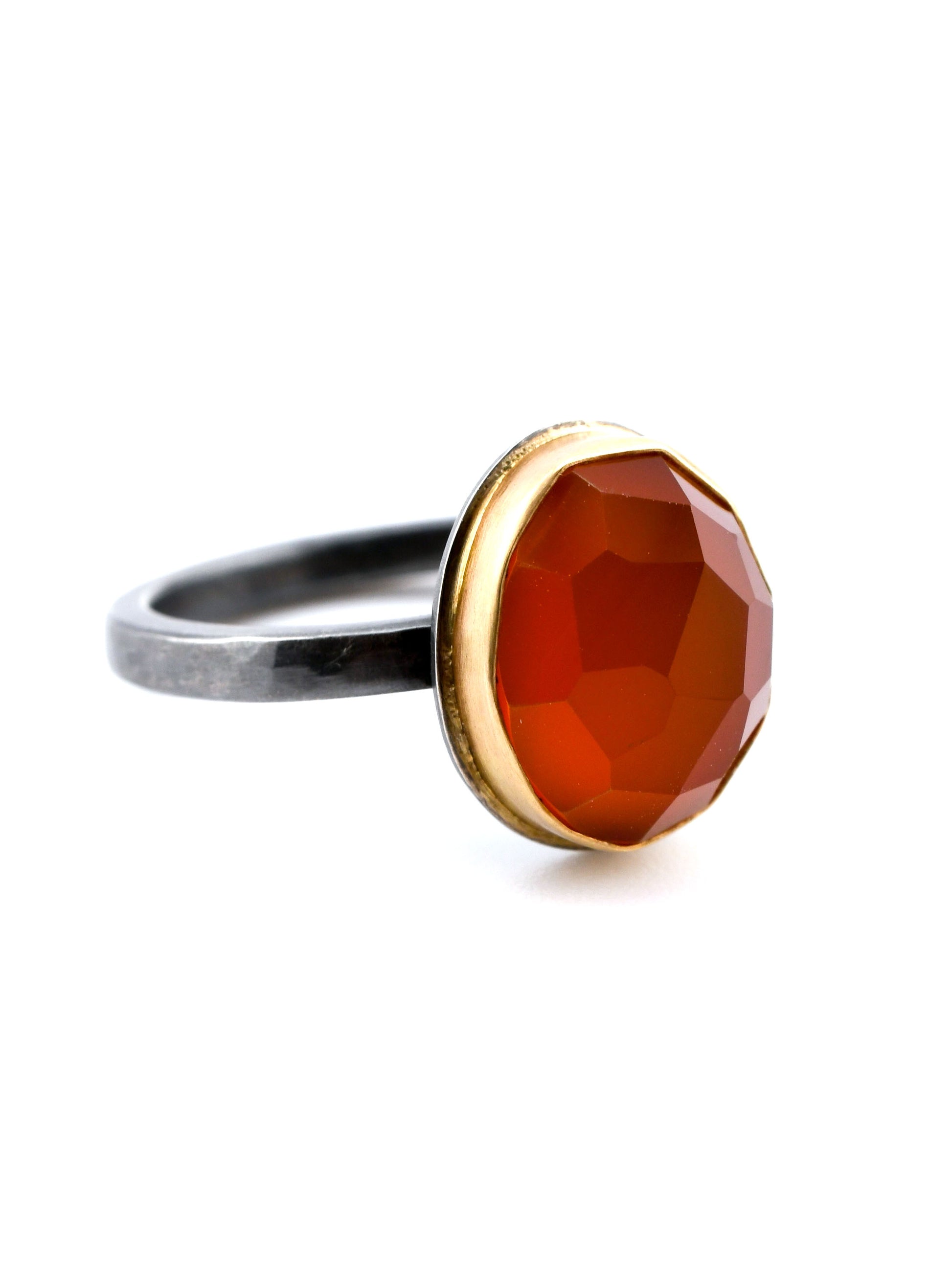 Ring with a red gemstone and gold accent on a white background