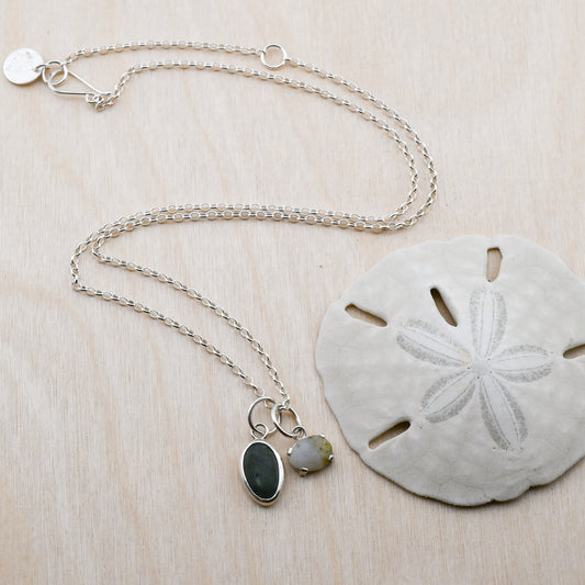 Silver necklace with two beach stone pendants on a sand dollar