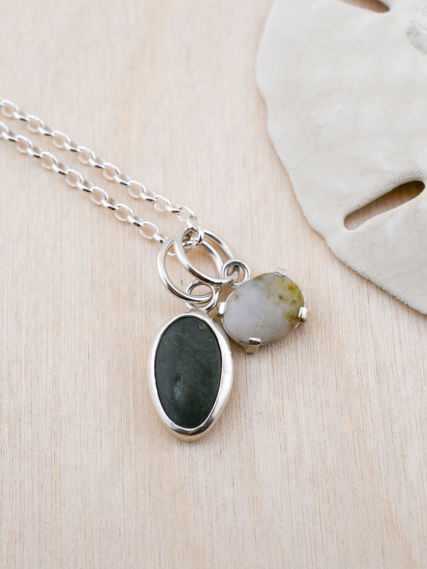 Necklace with two pendant beach stones on a wooden surface