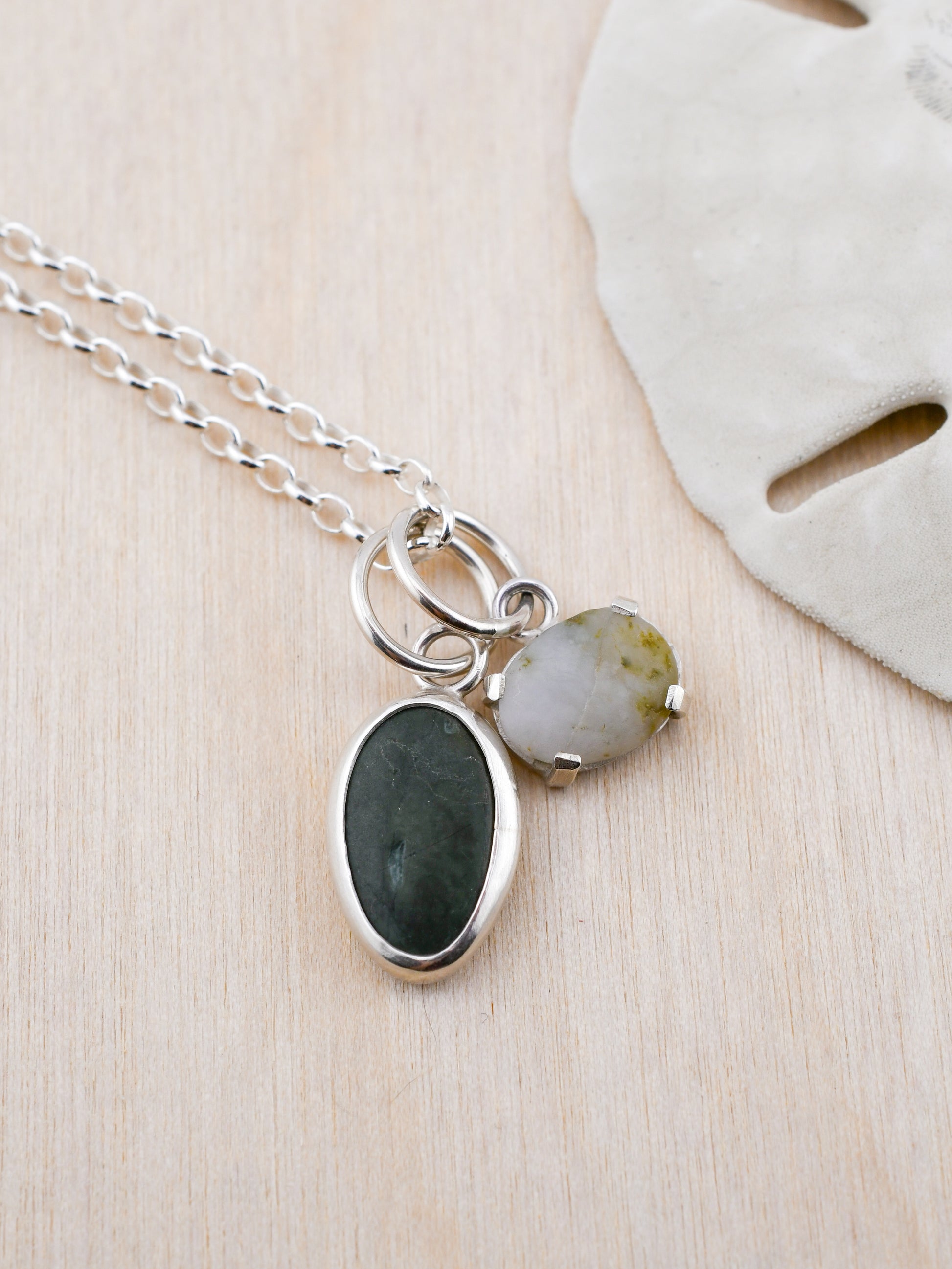 Necklace with two pendant beach stones on a wooden surface