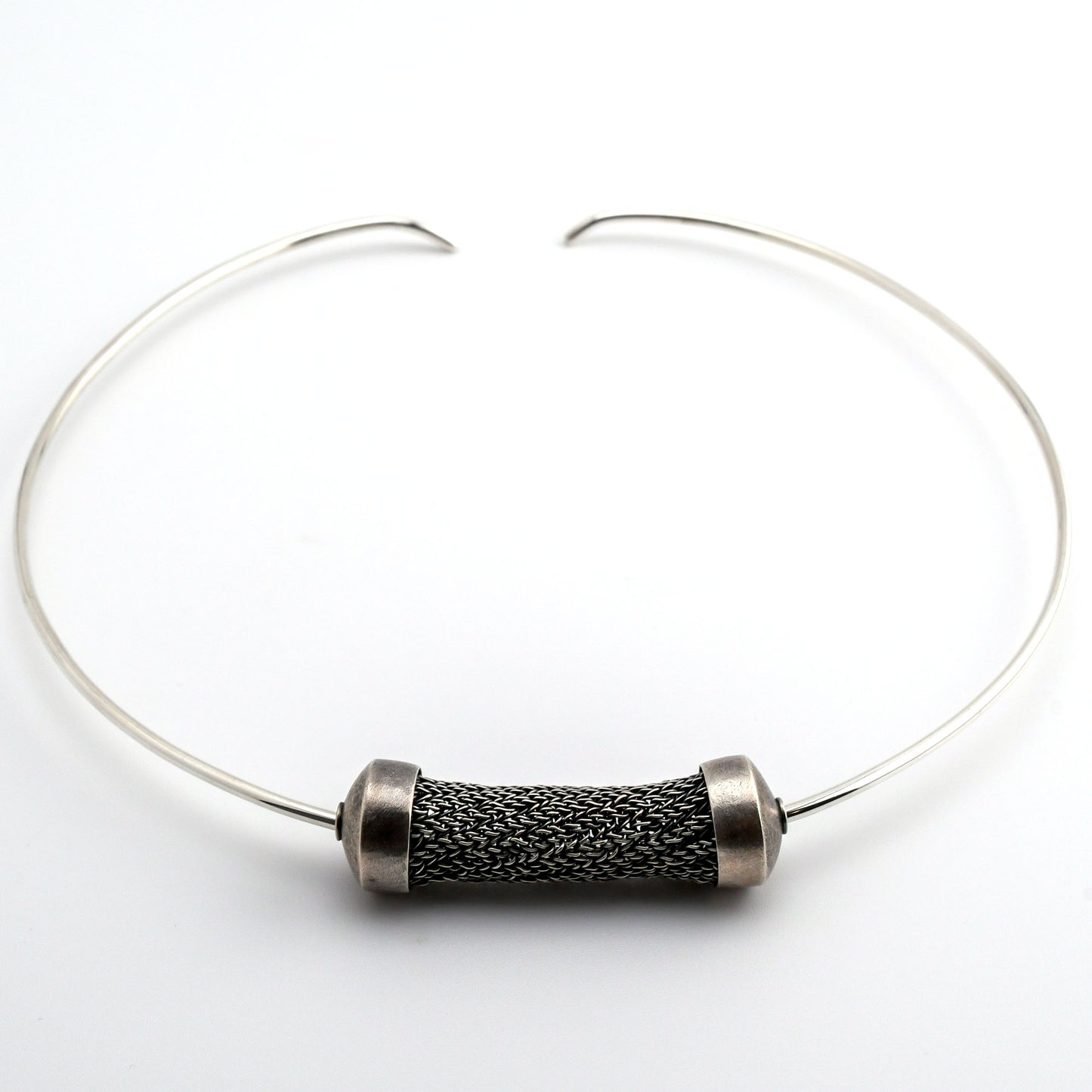 Silver torque necklace with large sculptural woven bead on a white background