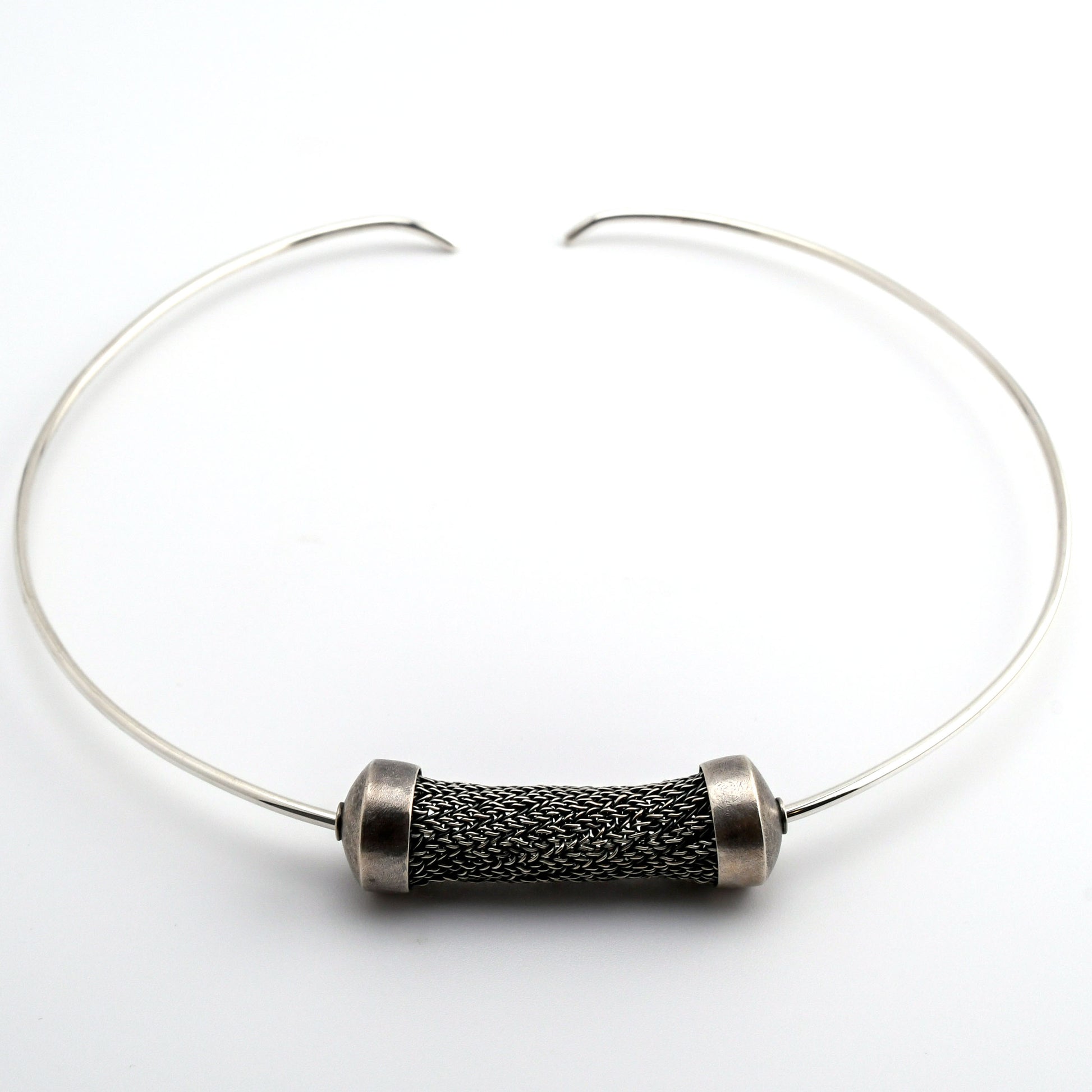 Silver torque necklace with large sculptural woven bead on a white background