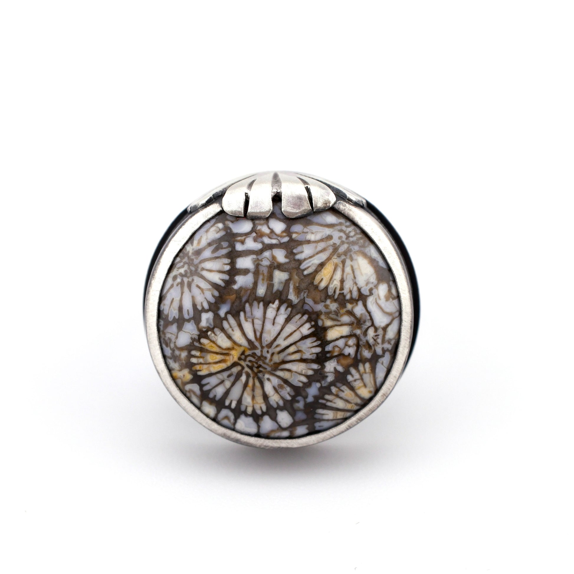 Silver ring with floral design on a white background