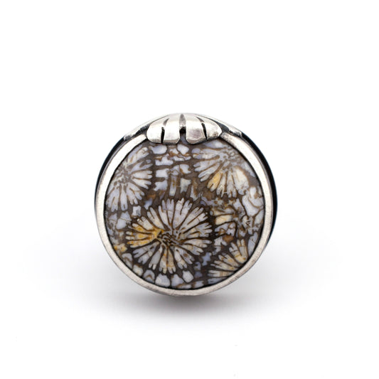 Silver ring with floral design on a white background