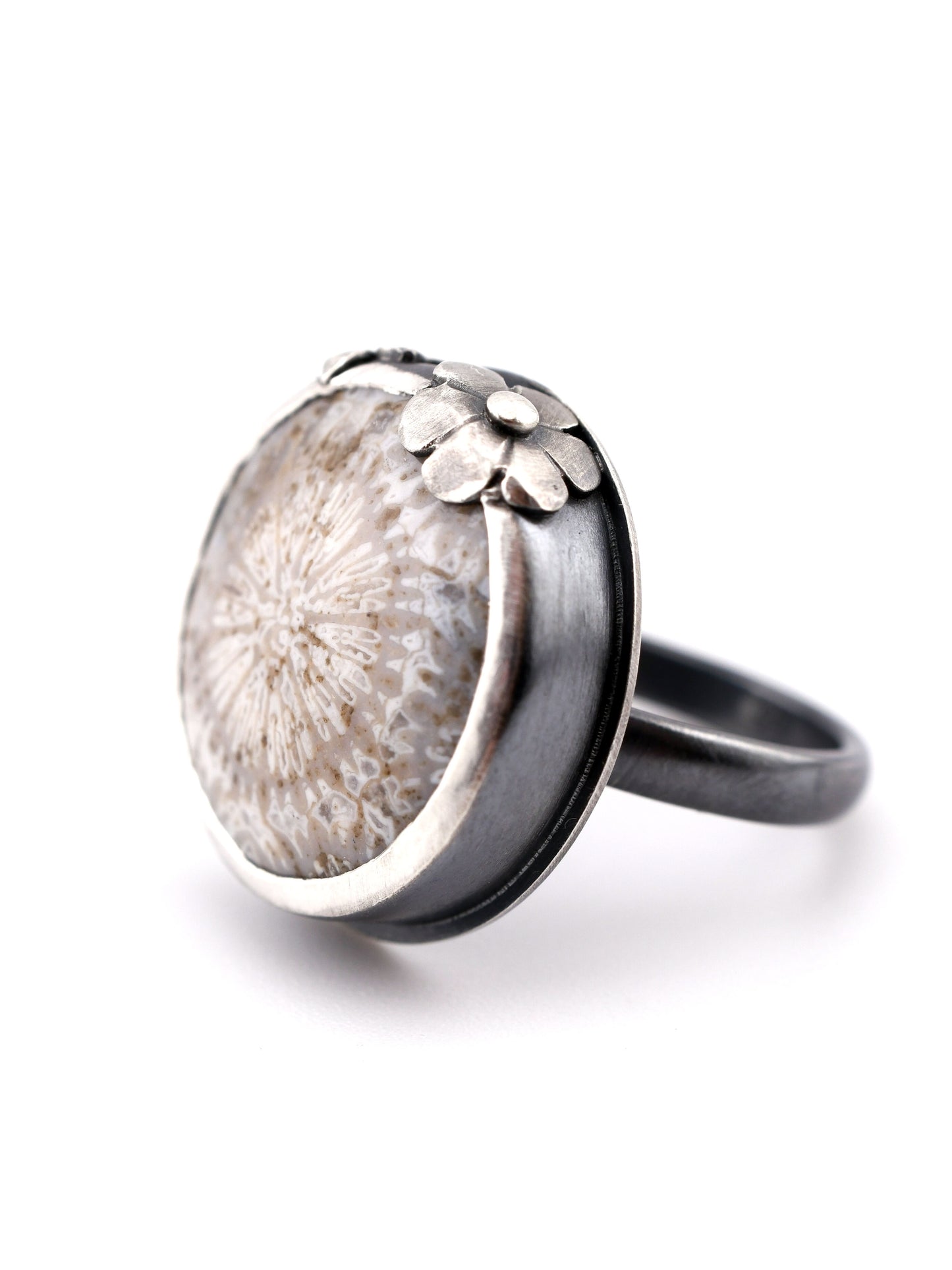 Silver ring with floral design on a white background