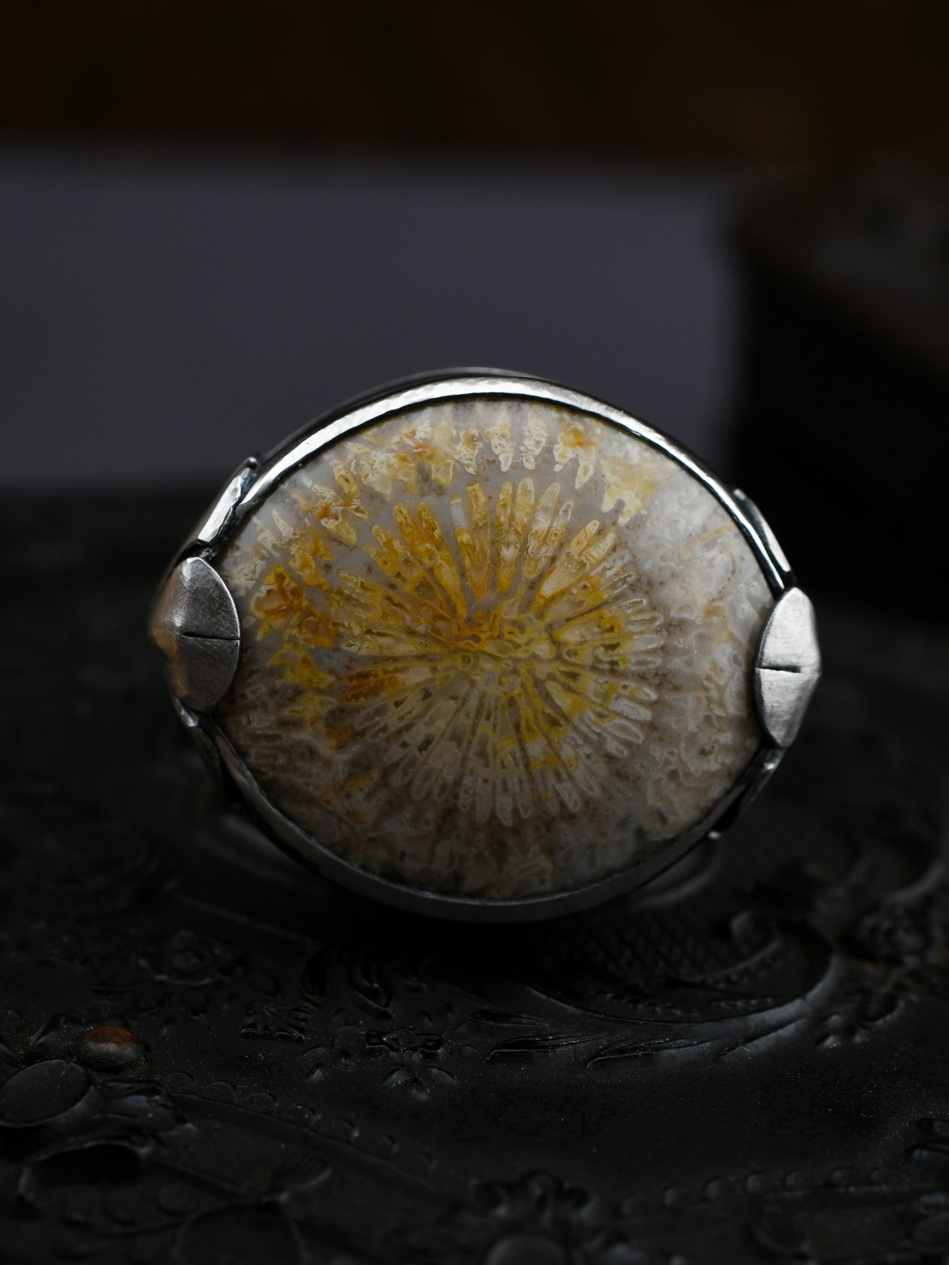 Ring with a natural stone and silver setting on a dark background