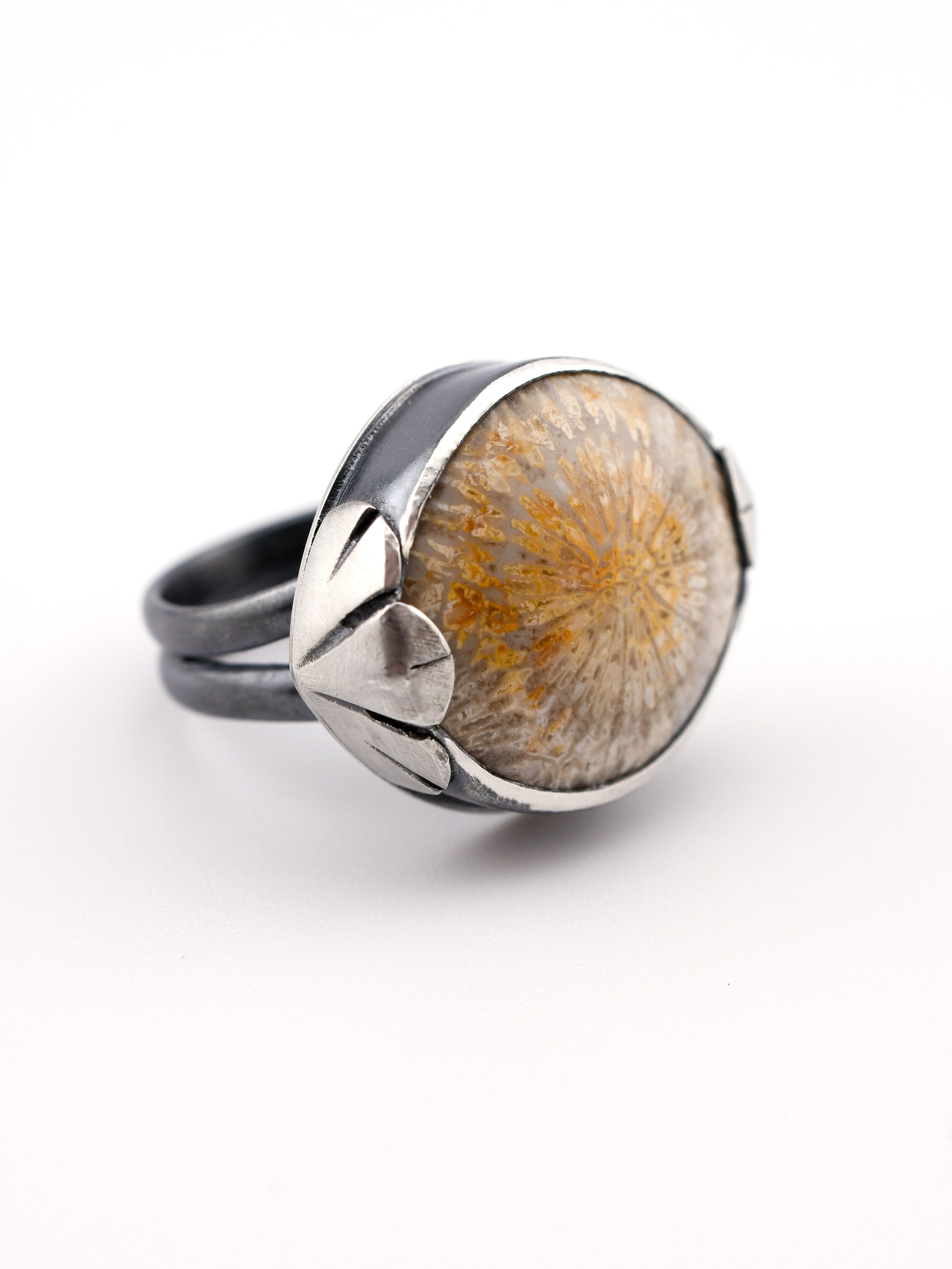 Silver ring with a floral design featuring a natural element on a white background