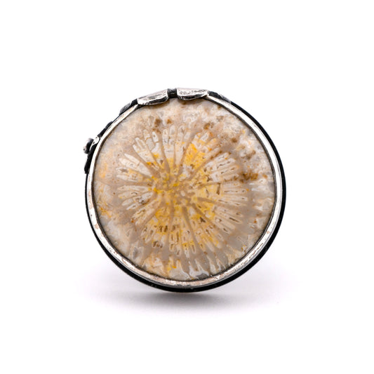 Round silver ring with a natural coral design on a white background