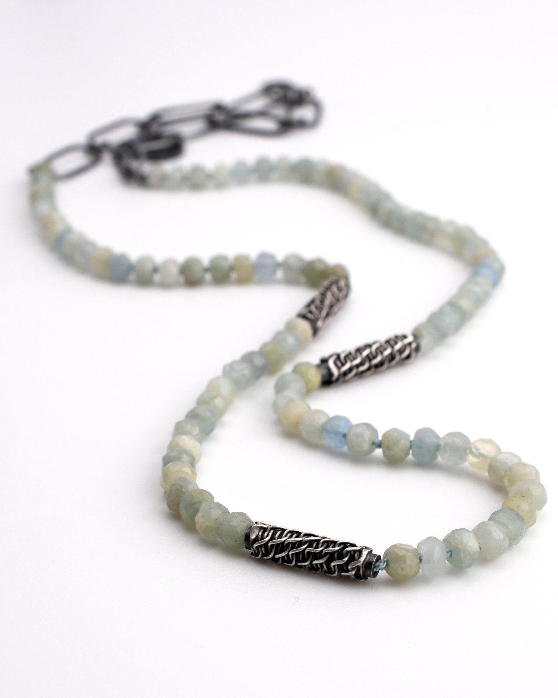 natural blue aquamarine beaded necklace with woven silver bead accents and black silver chain extender on a white background