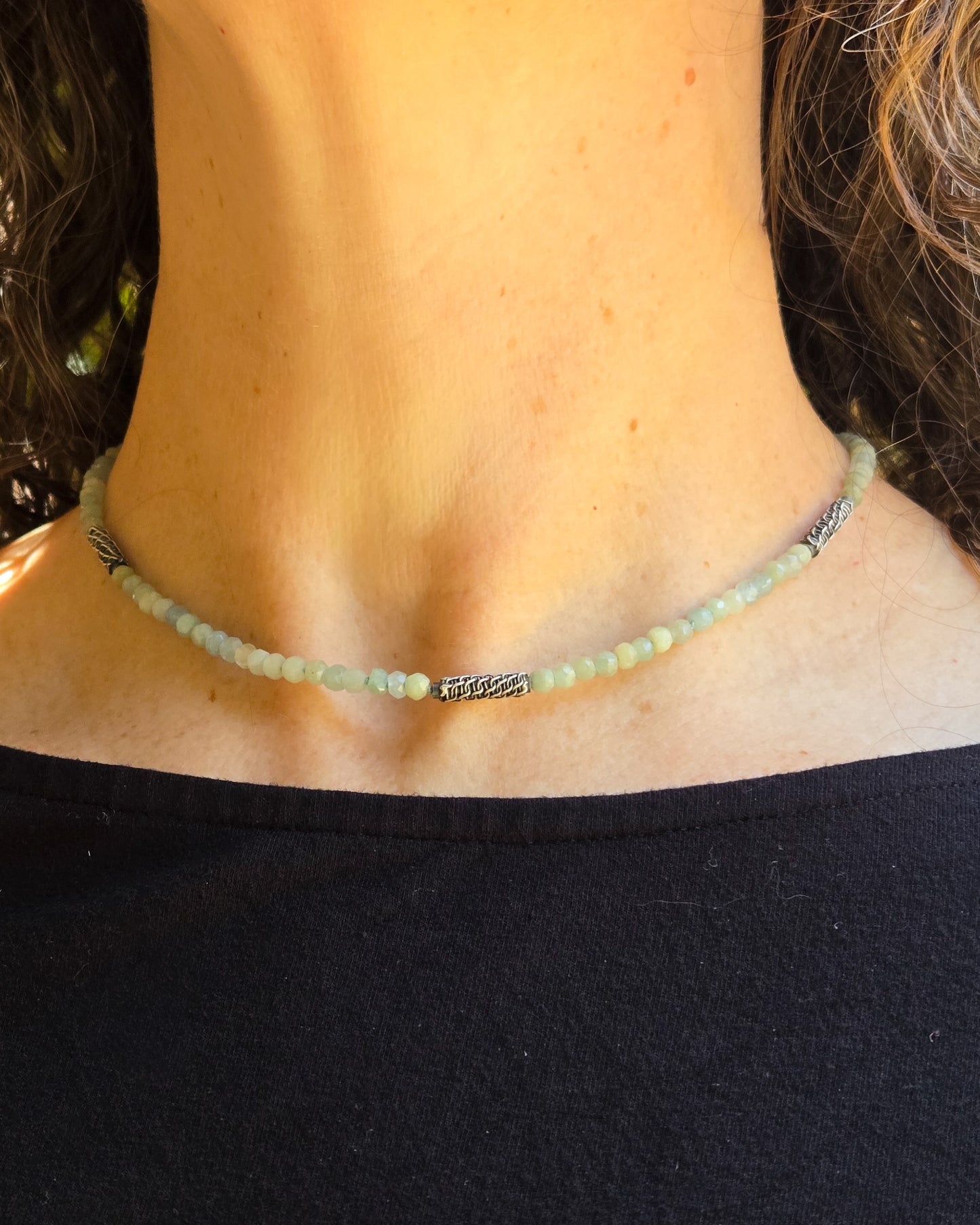 blue aquamarine beaded necklace with woven silver bead accents worn on a person close to the throat