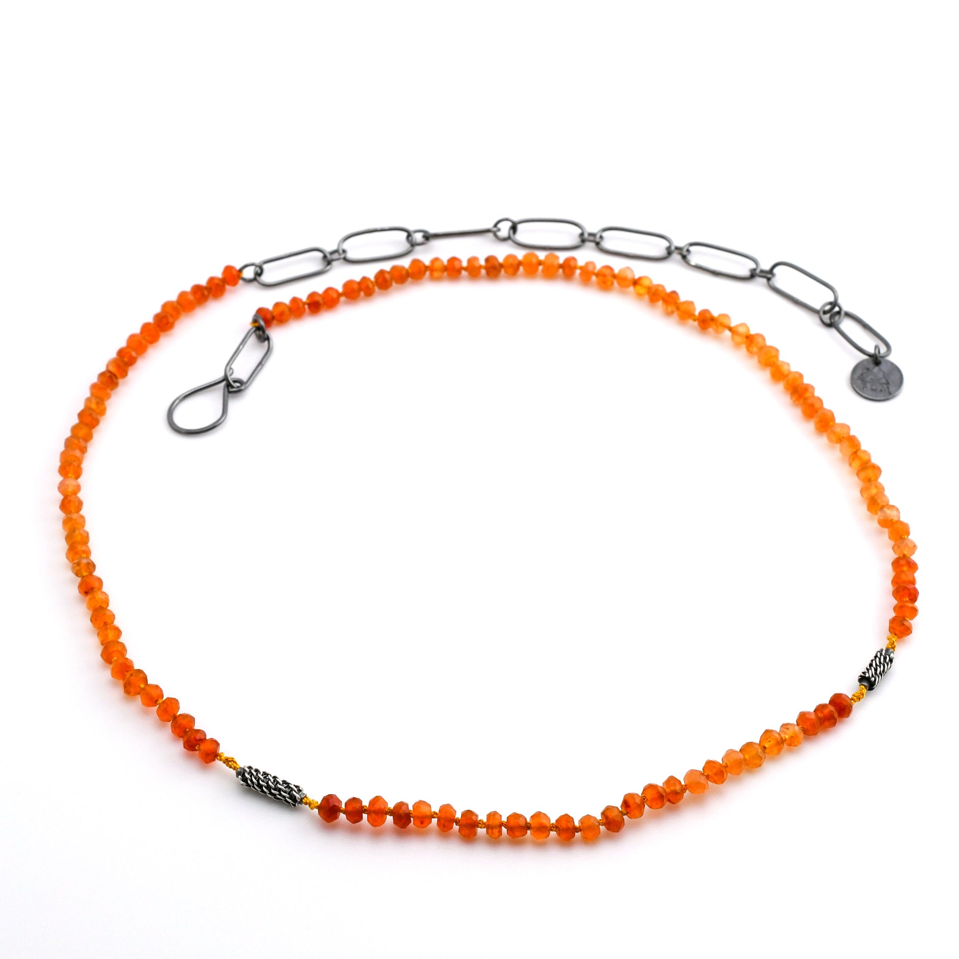 orange carnelian beaded necklace with woven silver bead accents and black silver chain extender on a white background