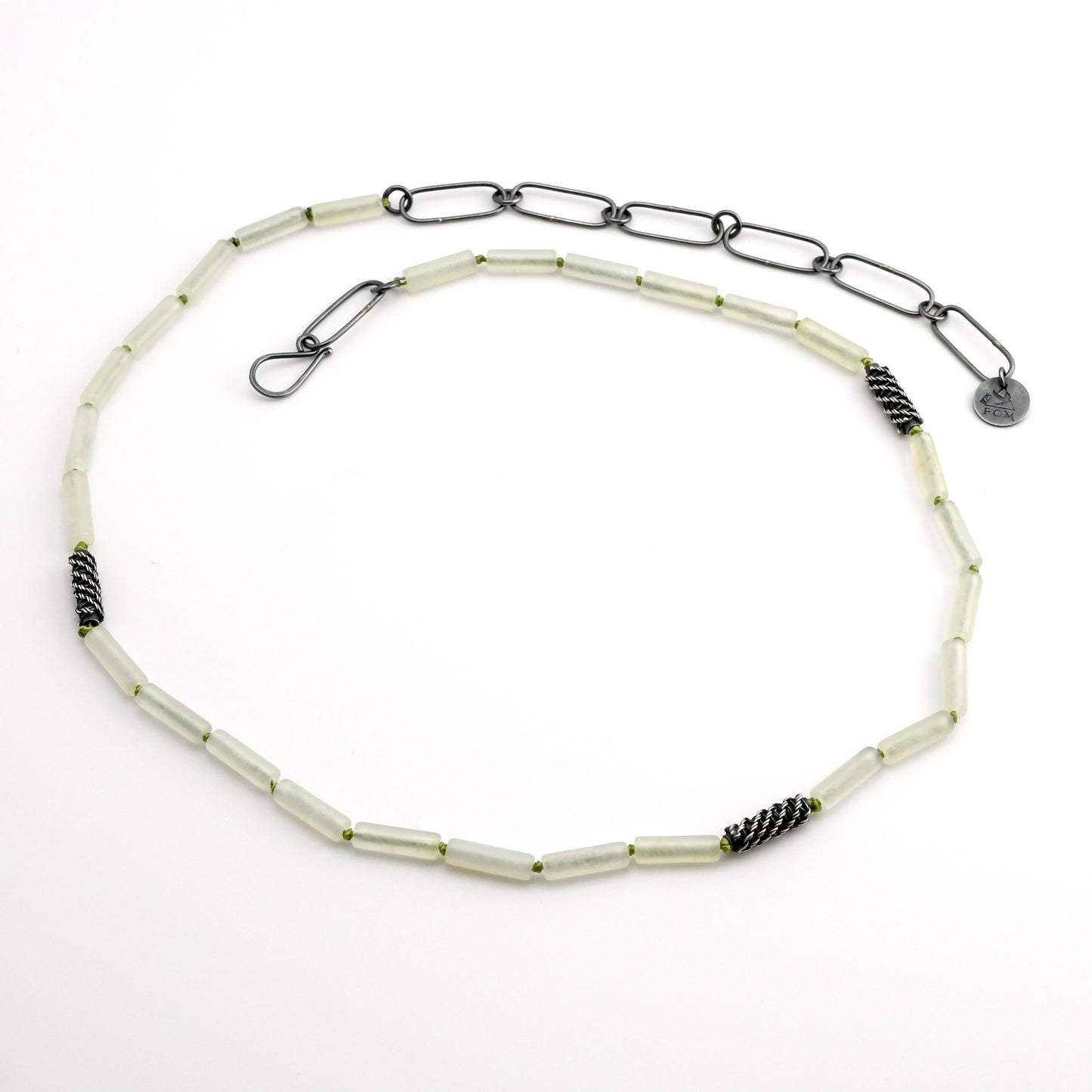 Pale green quartz beaded necklace with woven silver bead accents and black silver chain extender on a white background