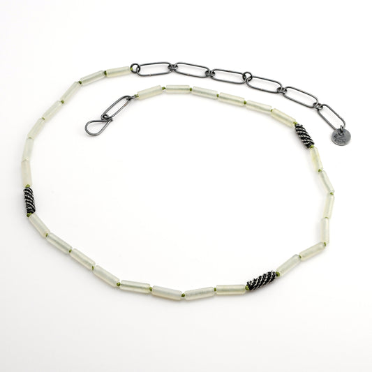 Pale green quartz beaded necklace with woven silver bead accents and black silver chain extender on a white background