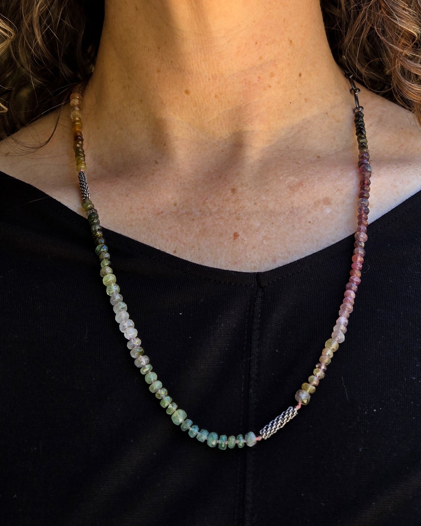 multicolored tourmaline beaded necklace with woven silver elements show worn at its longest length