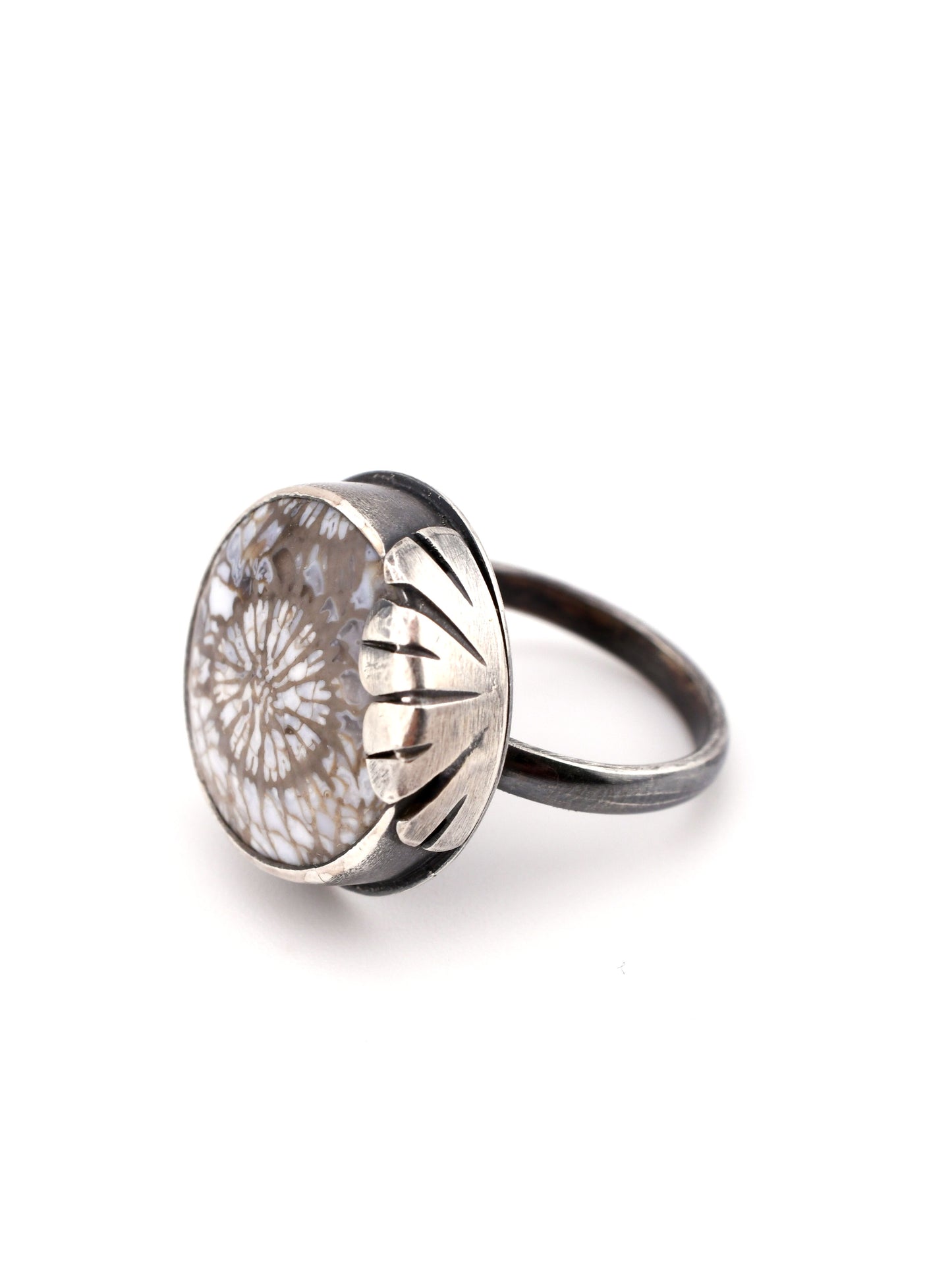 Silver ring with a floral design on a white background