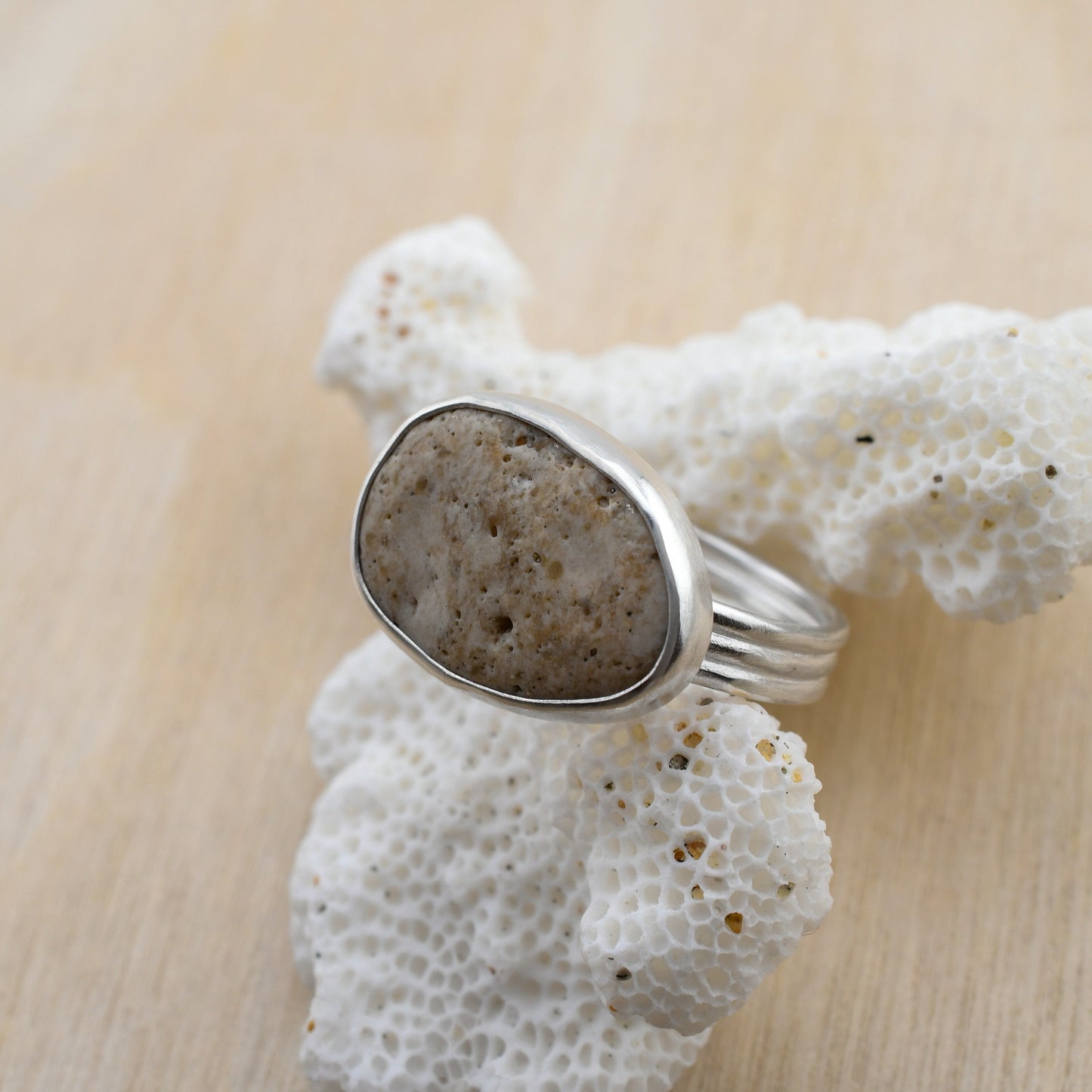 Silver ring with a natural stone on a piece of white coral