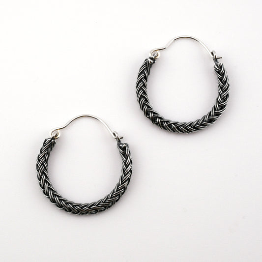 Pair of braided hoop earrings on a white background