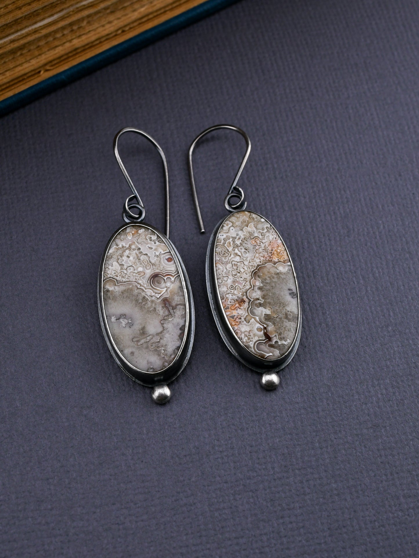 Pair of earrings with natural stone design on a dark surface