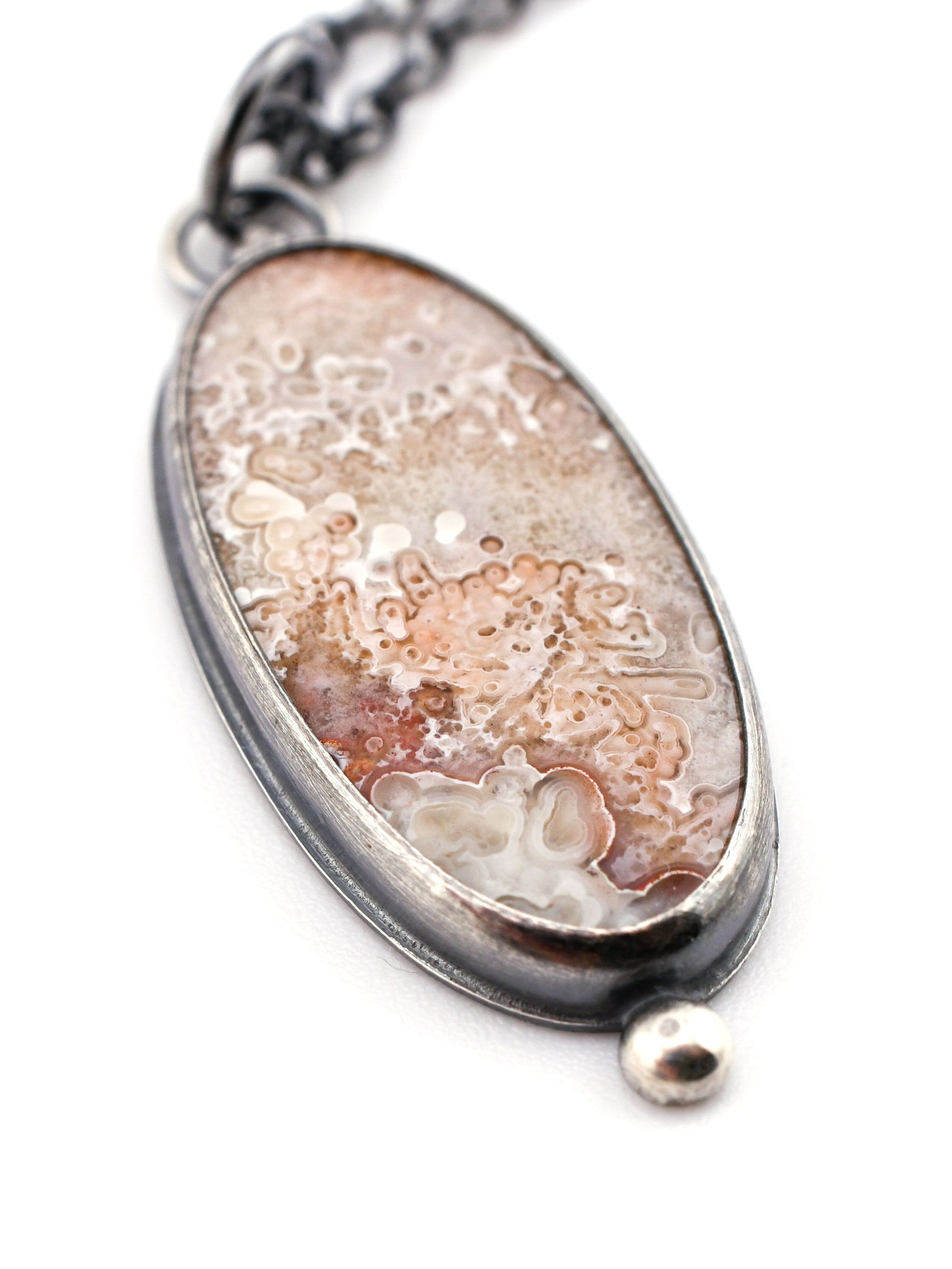 Necklace with an oval pendant on a white background
