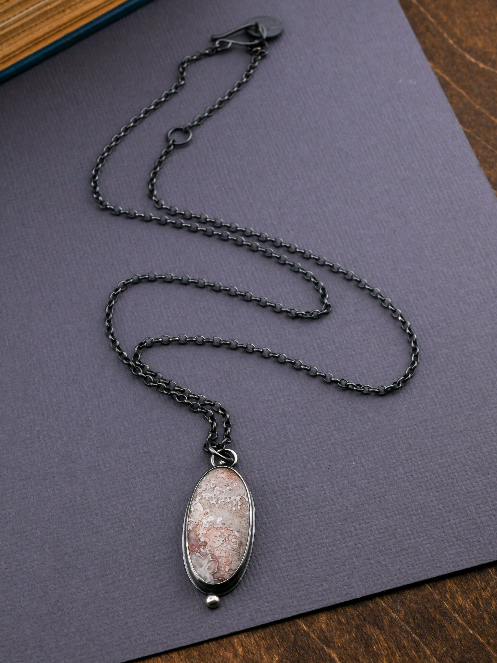 Necklace with a pendant on a gray surface