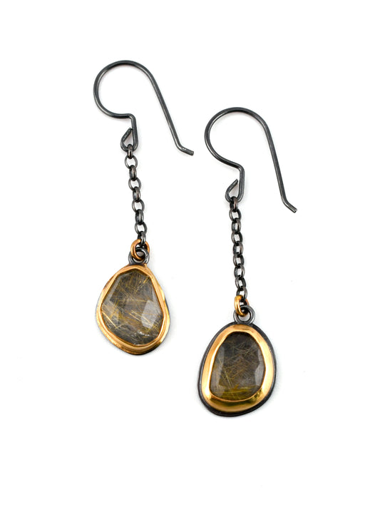 Pair of earrings with teardrop-shaped gemstones on a white background