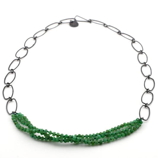 Necklace with green beads and black chain on a white background