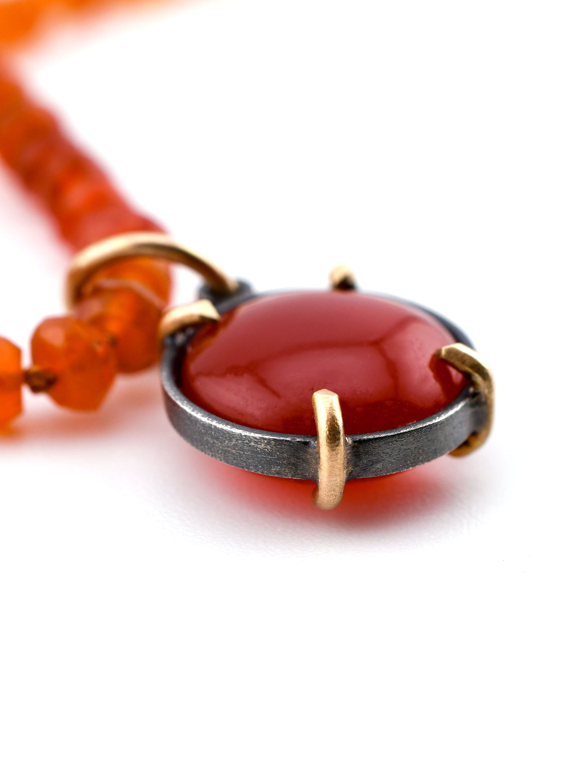 Necklace with a red pendant and gold accents on a white background