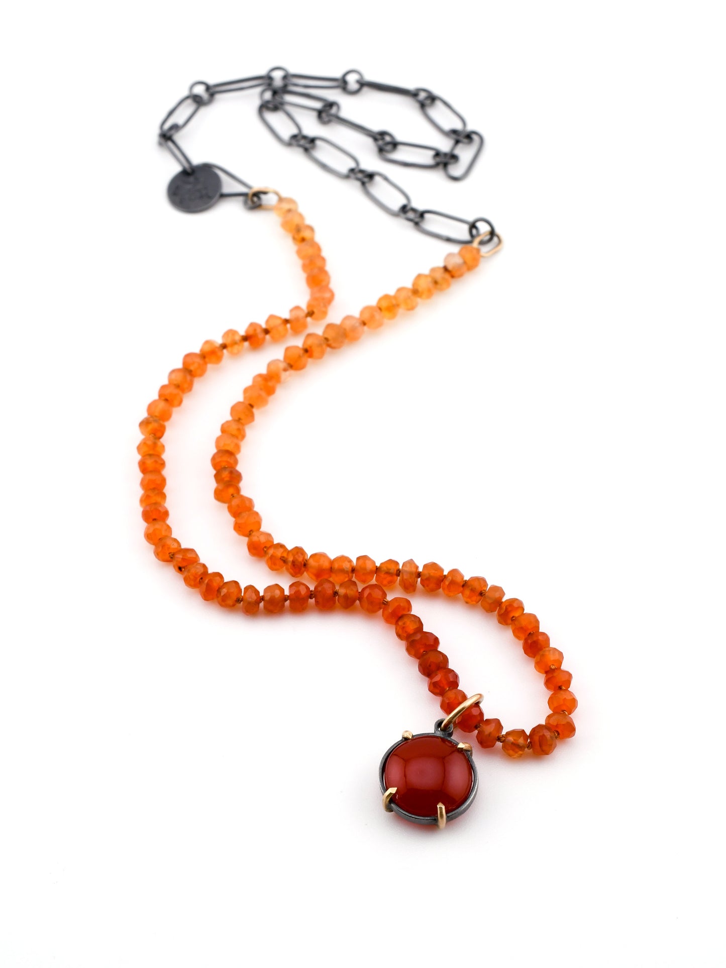 Necklace with orange beads and a red pendant on a white background