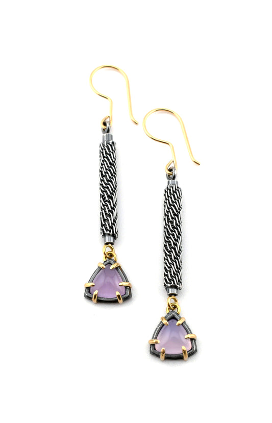 Pair of earrings with purple gemstones and gold accents on a white background