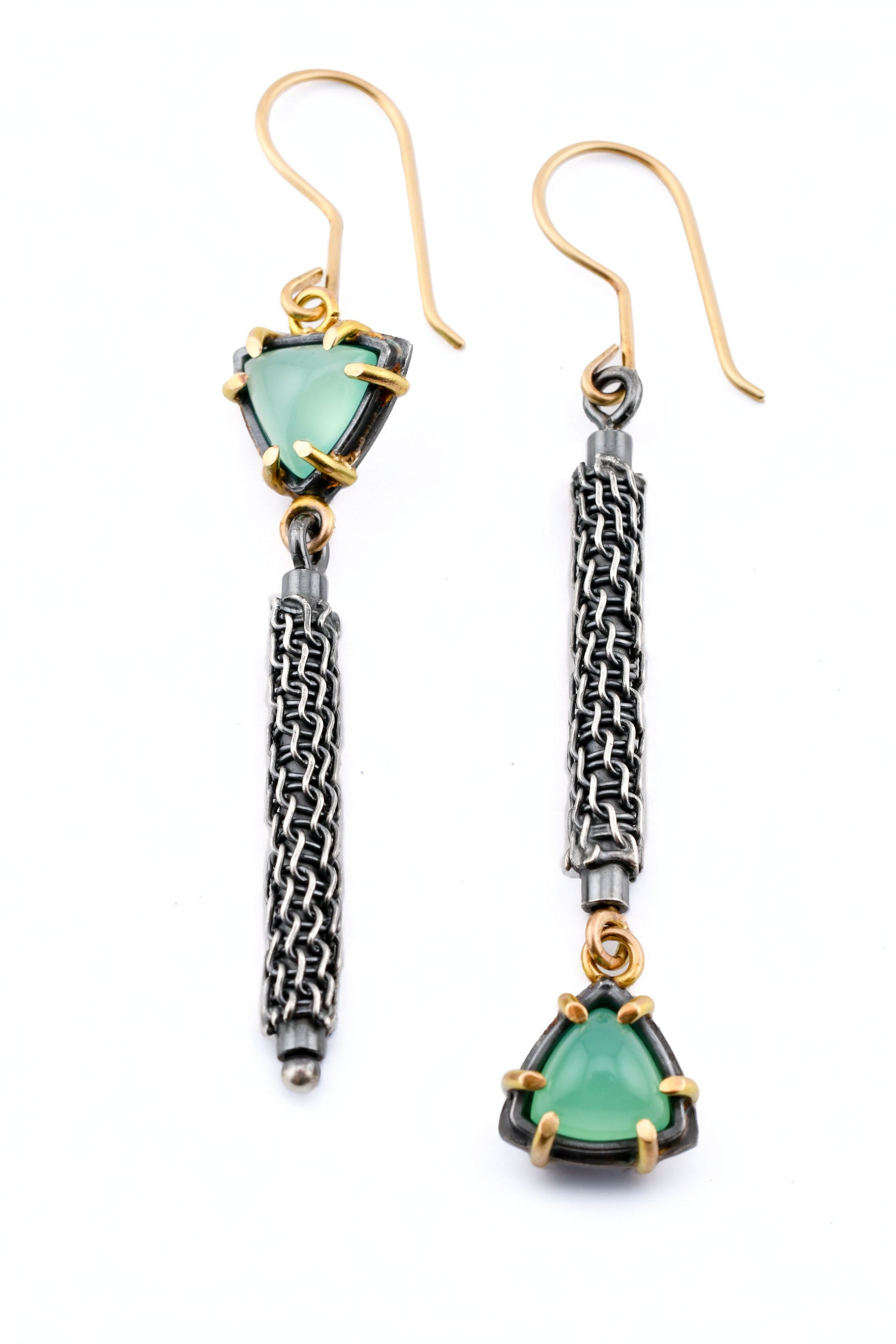 Pair of earrings with green gemstones and gold accents on a white background
