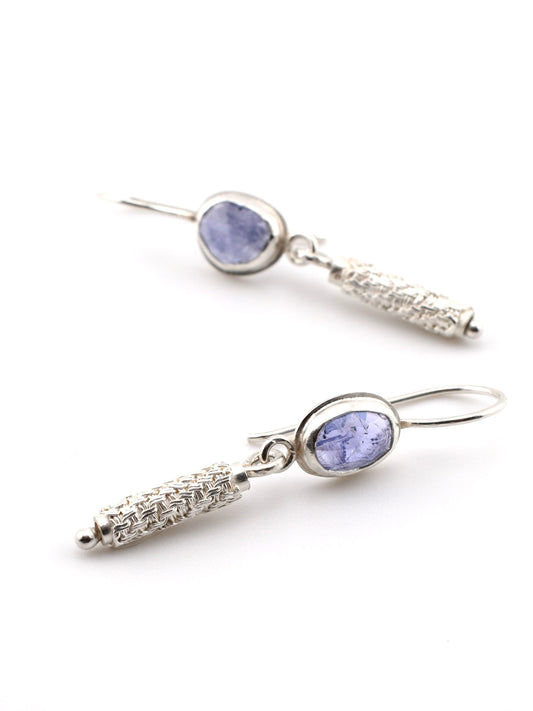 Silver earrings with purple gemstones on a white background