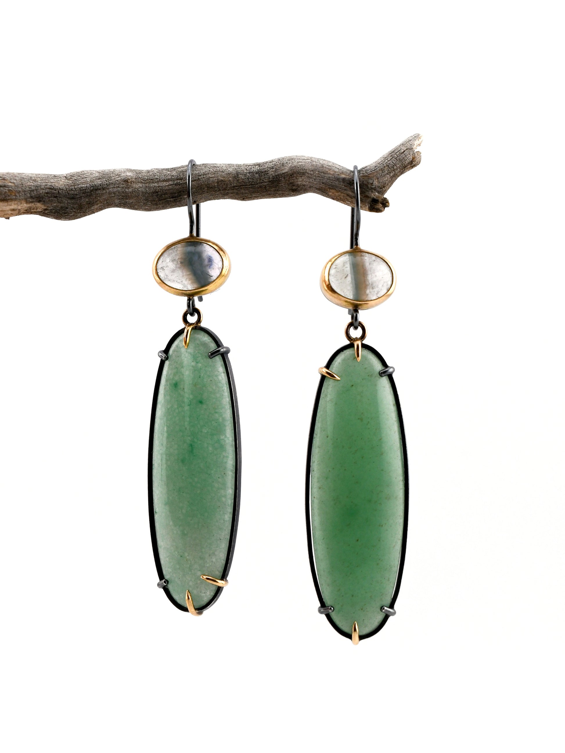 Green Aventurine earrings with gold accents on a branch against a white background