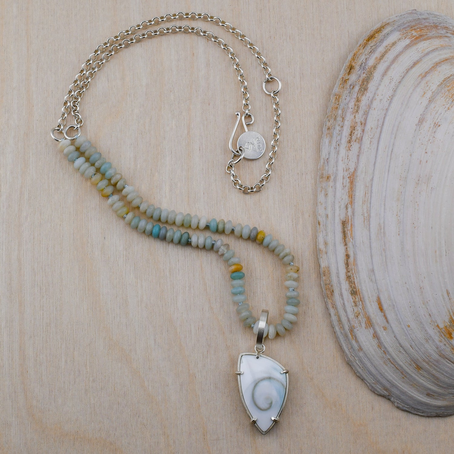 Necklace with a shell pendant on a wooden surface