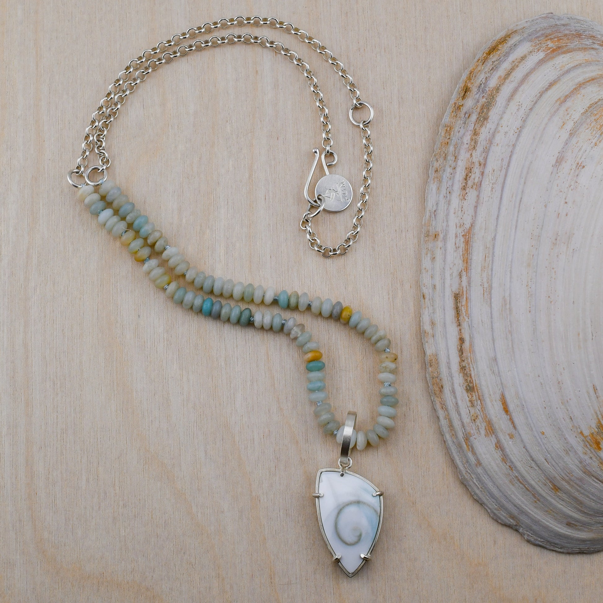 Necklace with a shell pendant on a wooden surface