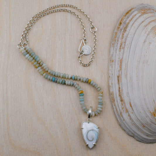Necklace with a shell pendant on a wooden surface