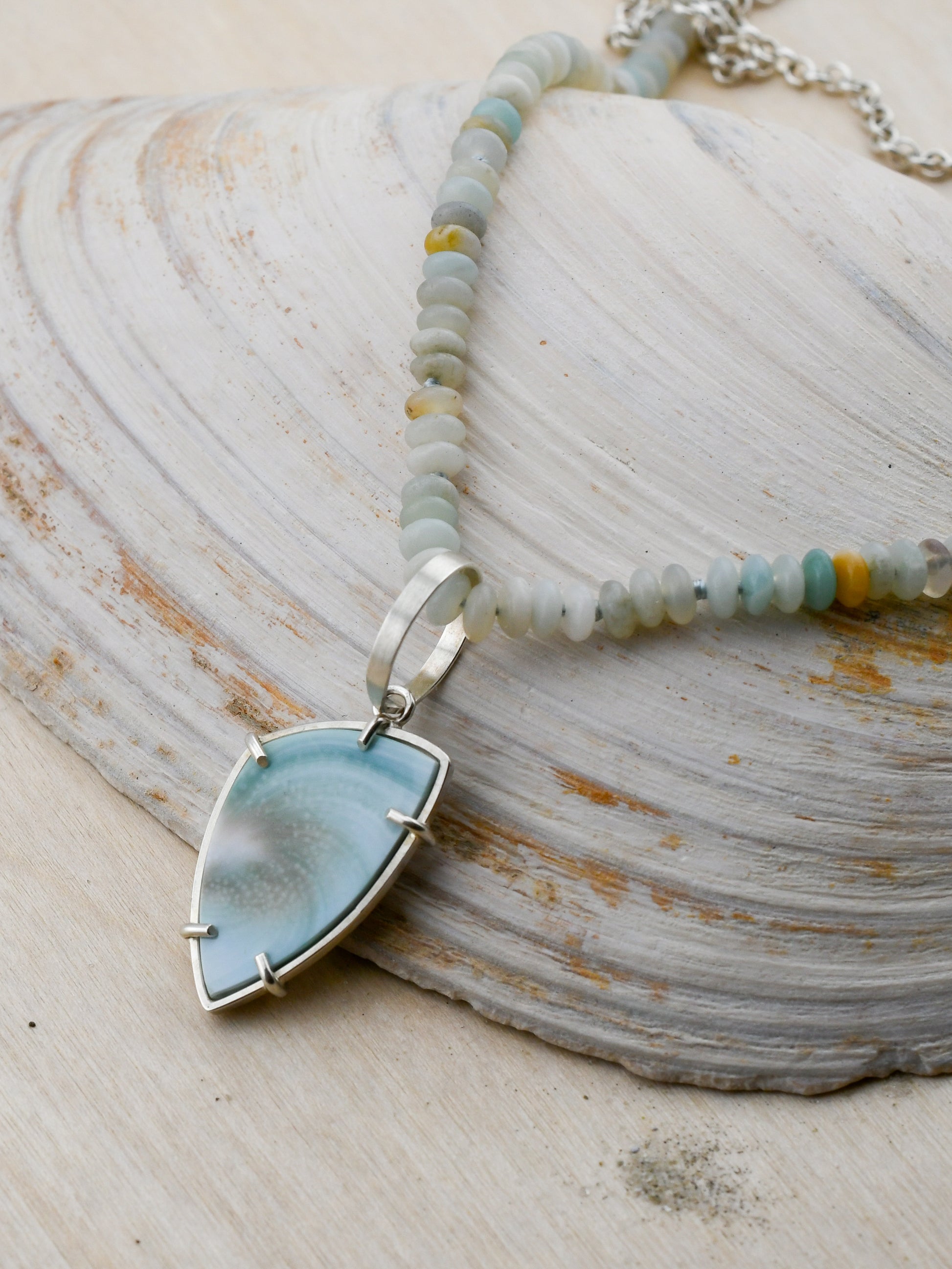 Amazonite beaded necklace with Shiva shell pendant on a neutral background